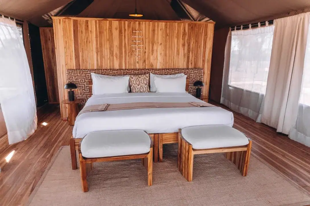Tented suite with a wooden bed and canvas walls