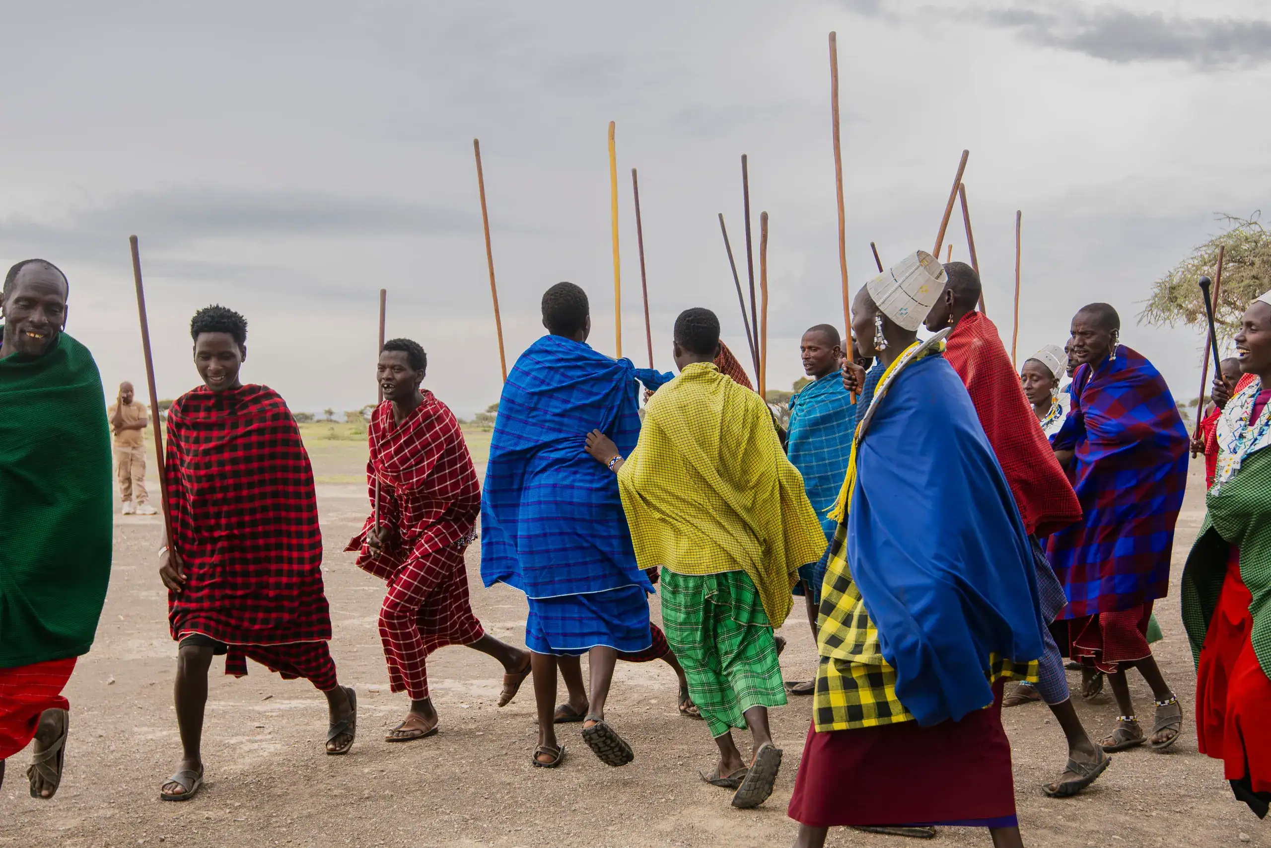 Maasai men in traditional shukas with walking sticks